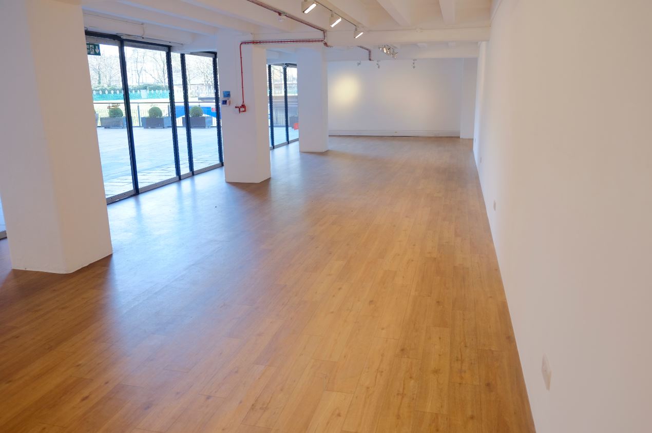 Spacious event space at gallery@oxo with polished wooden floors and natural light.