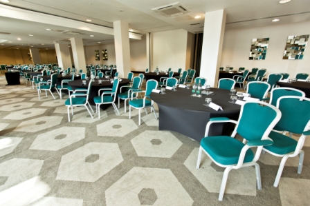 Westminster Suite at Hilton London Olympia, modern event space with teal chairs for conferences.