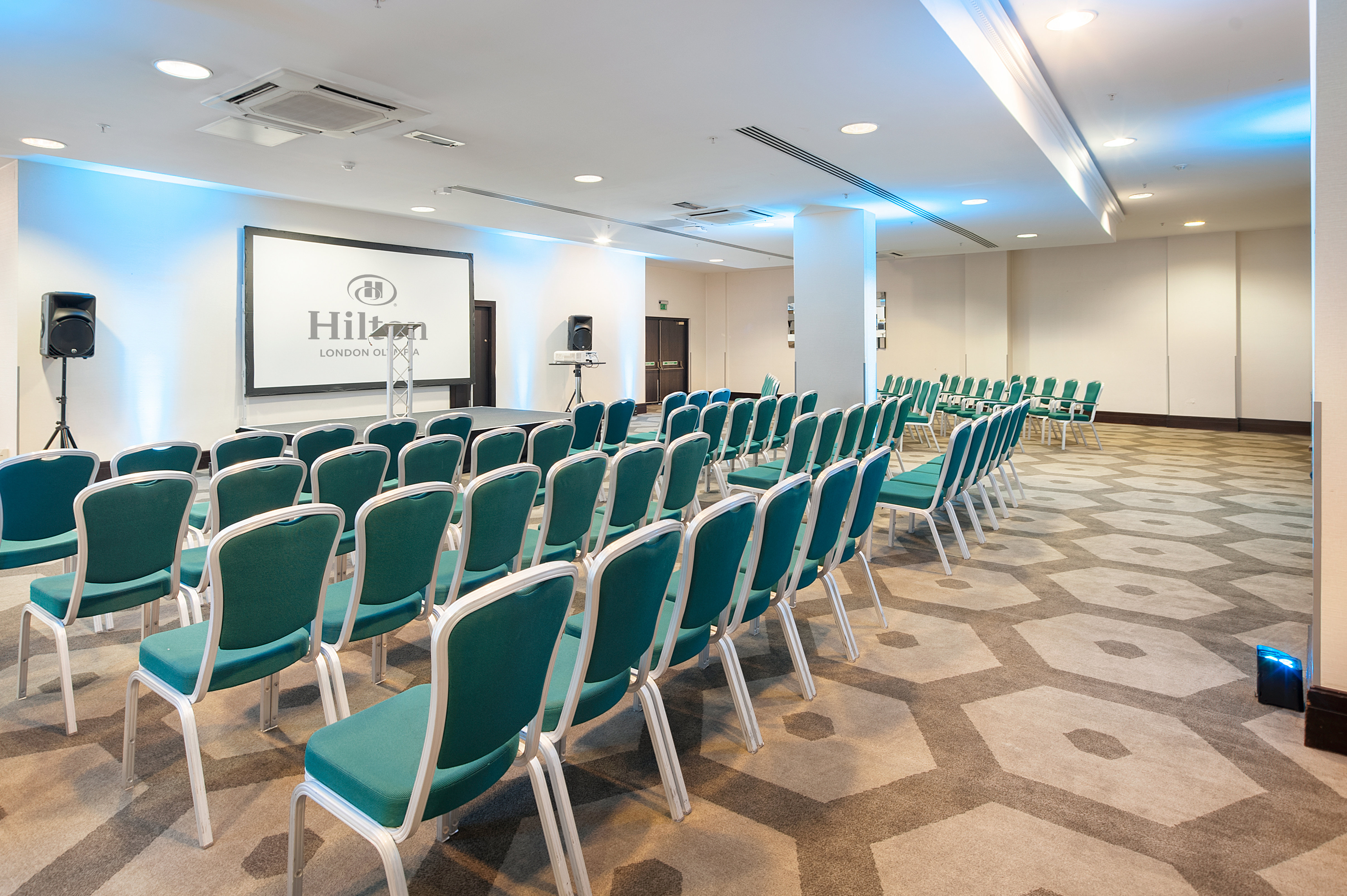 Westminster Suite at Hilton London Olympia, teal chairs arranged for corporate events.