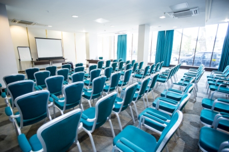 Tower Room at Hilton London Olympia with teal chairs, perfect for meetings and workshops.