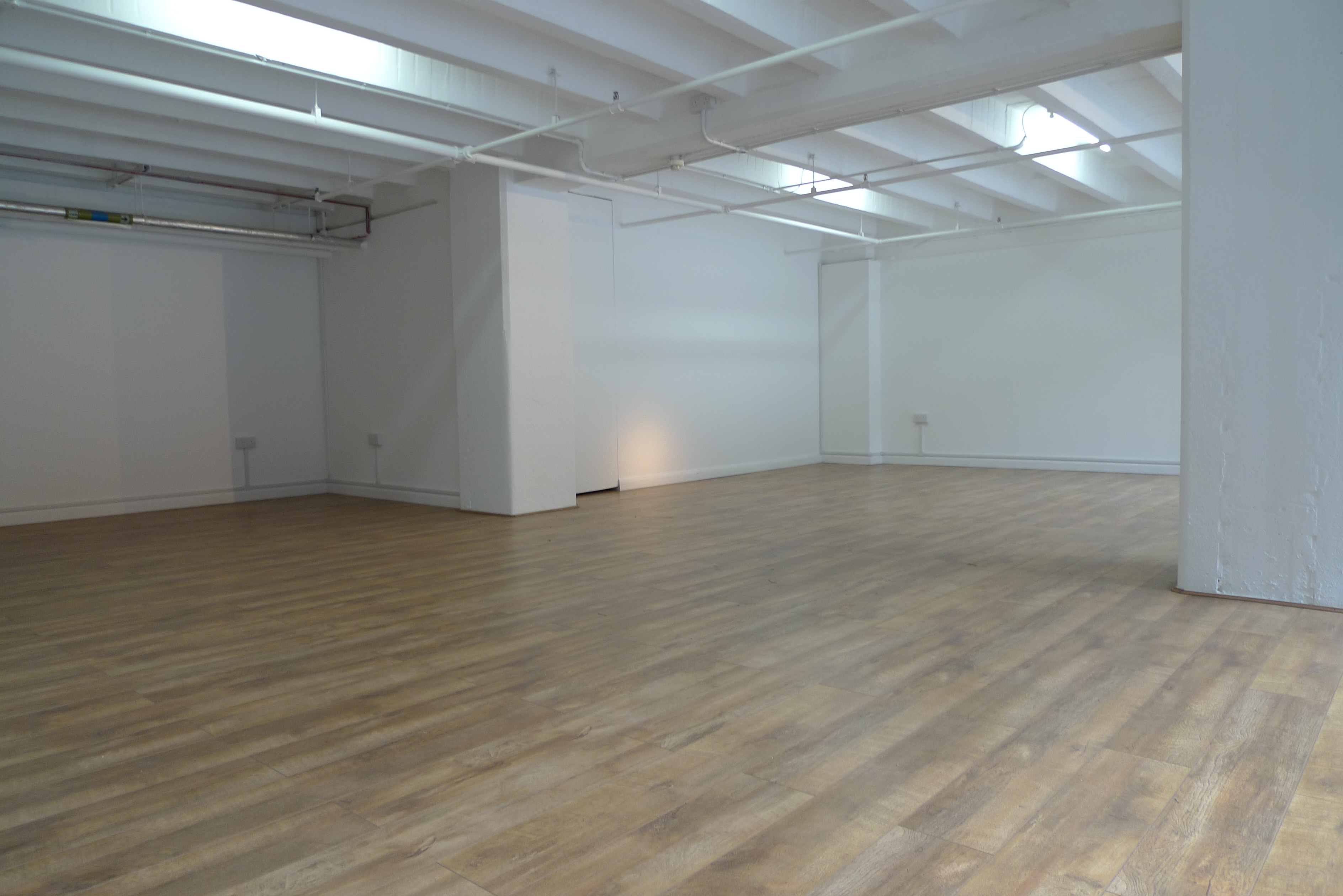 Versatile event space G11 in OXO Tower with natural light and polished wooden floor.