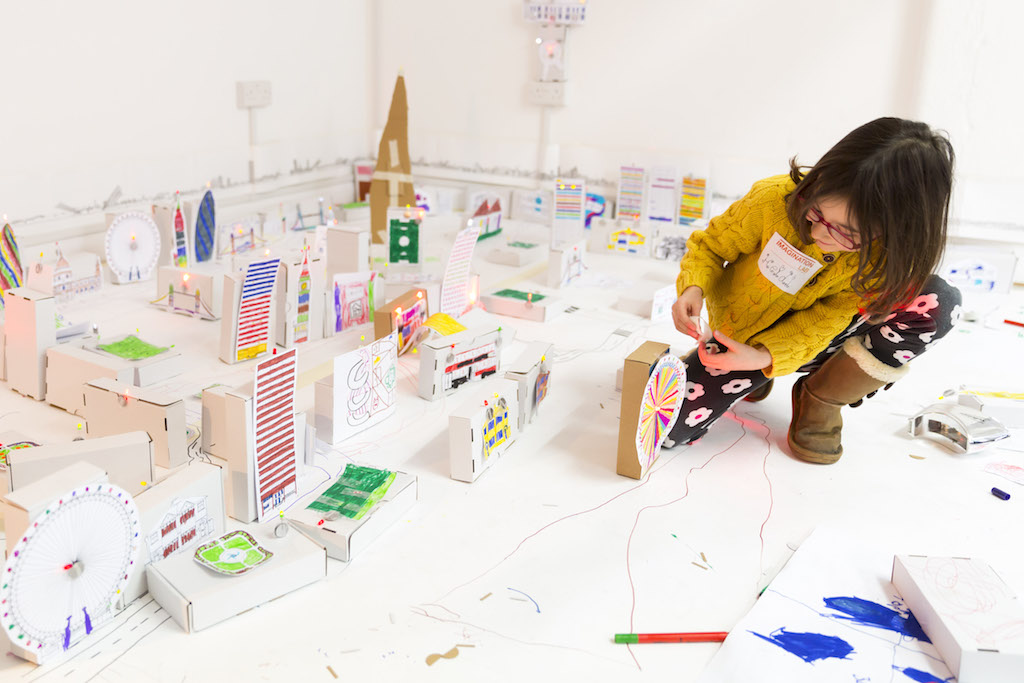 Young participant building a miniature city model at G11 OXO Tower creative workshop.