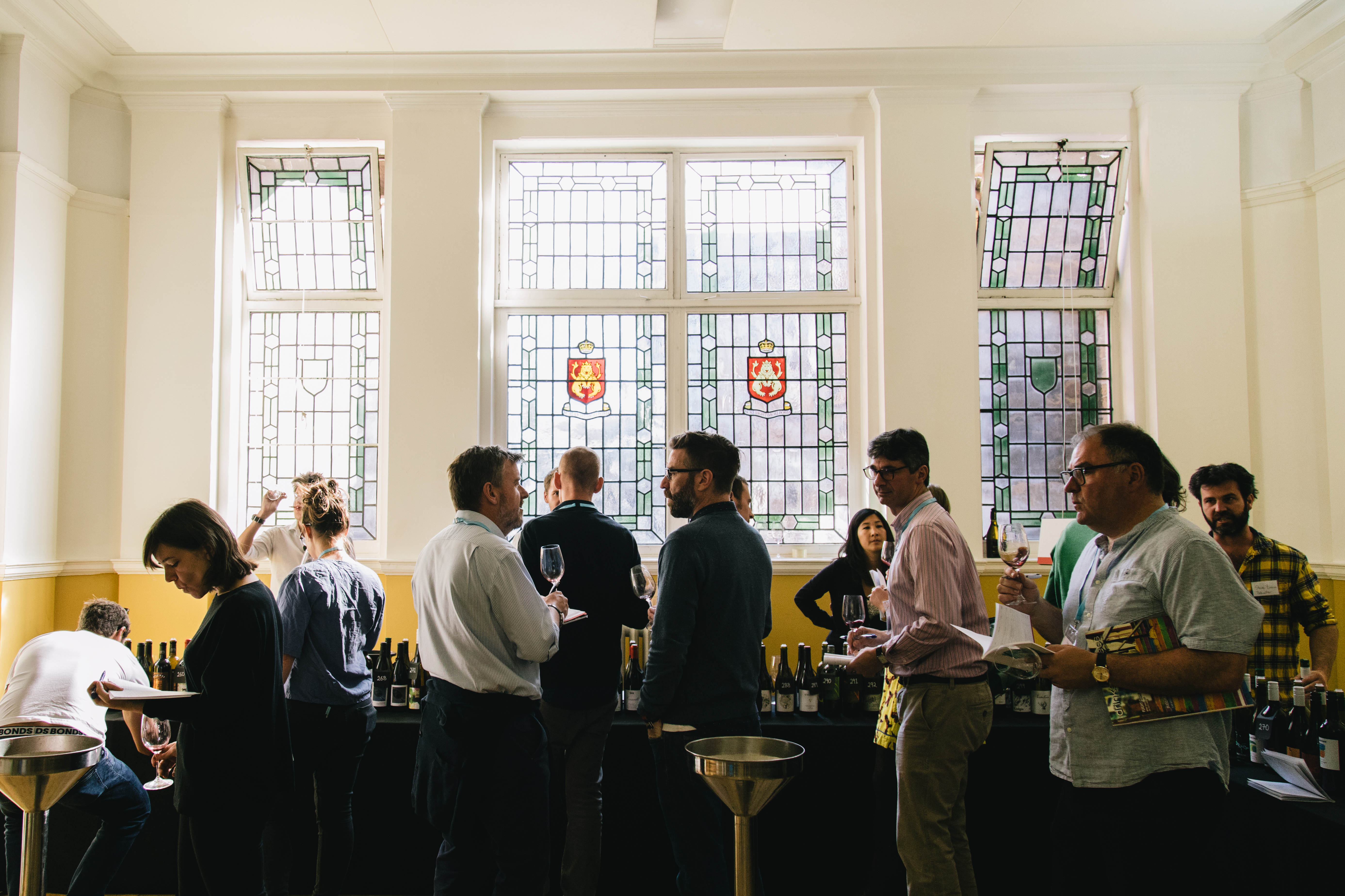Vibrant networking event in Shoreditch Town Hall's Mayor's Parlour with stained glass windows.