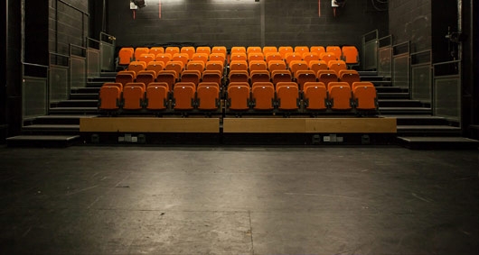 New Diorama Theatre auditorium with vibrant orange seating for performances and events.