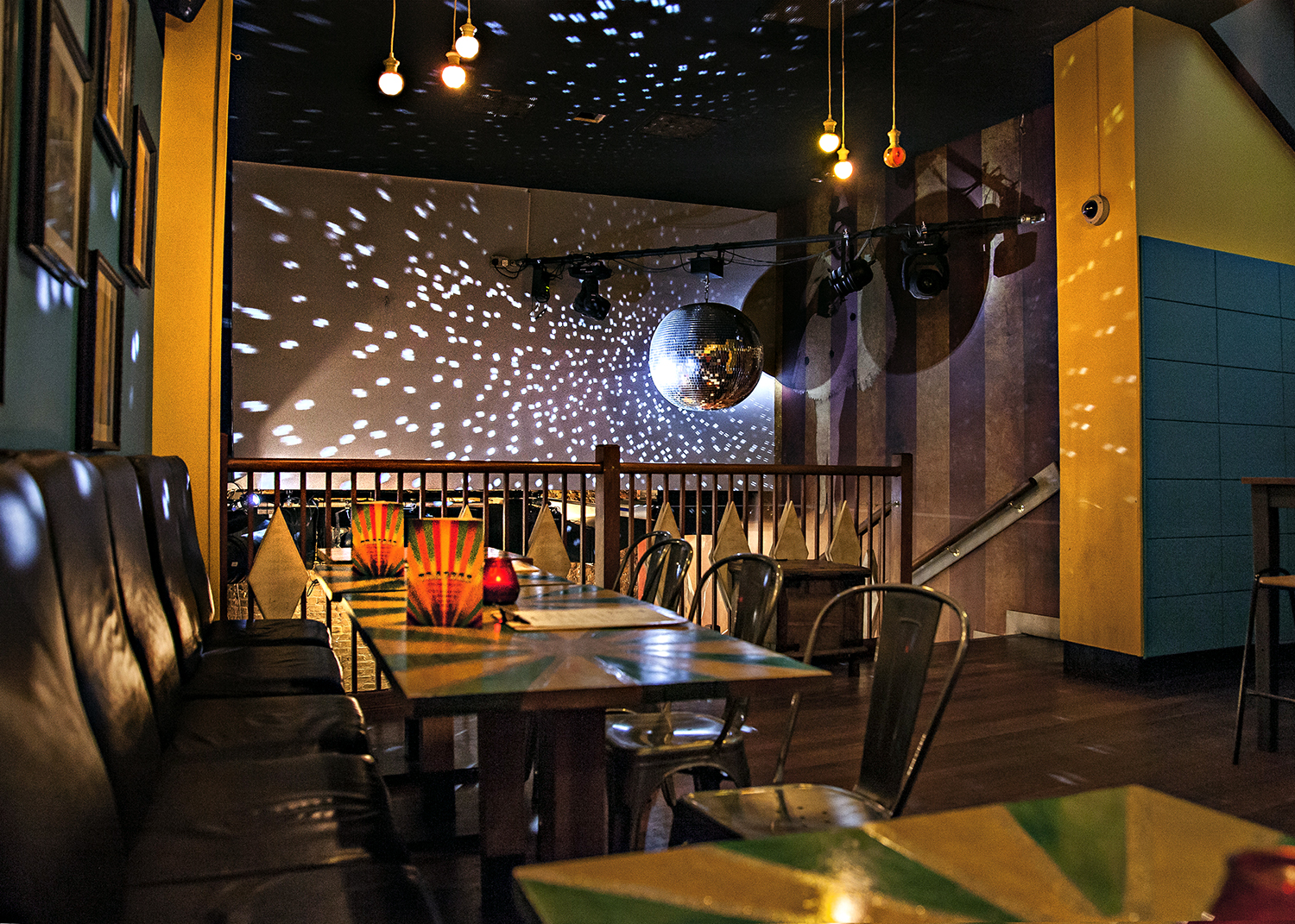 Vibrant Trapeze Bar main event space with colorful decor and disco ball for celebrations.
