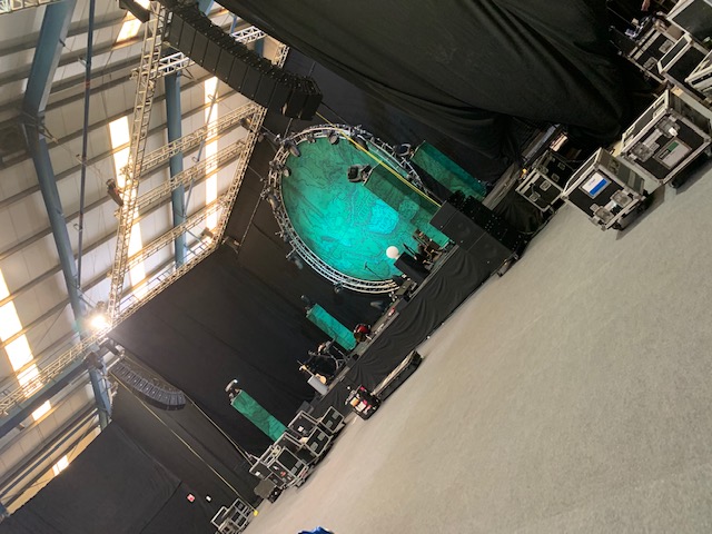 Showering Pavilion stage setup with green backdrop for live event at Bath & West Showground.