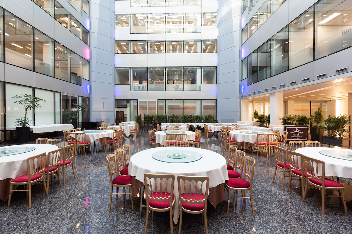 Spacious modern event venue with round tables, perfect for networking and dining.