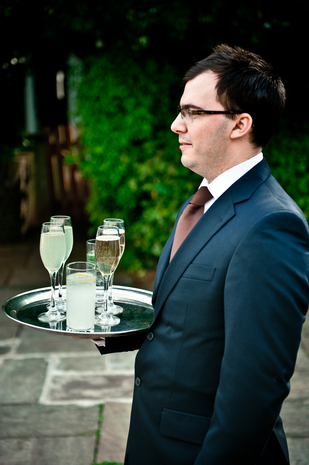 Professional server balancing glasses at outdoor event on Ravens Ait Island.