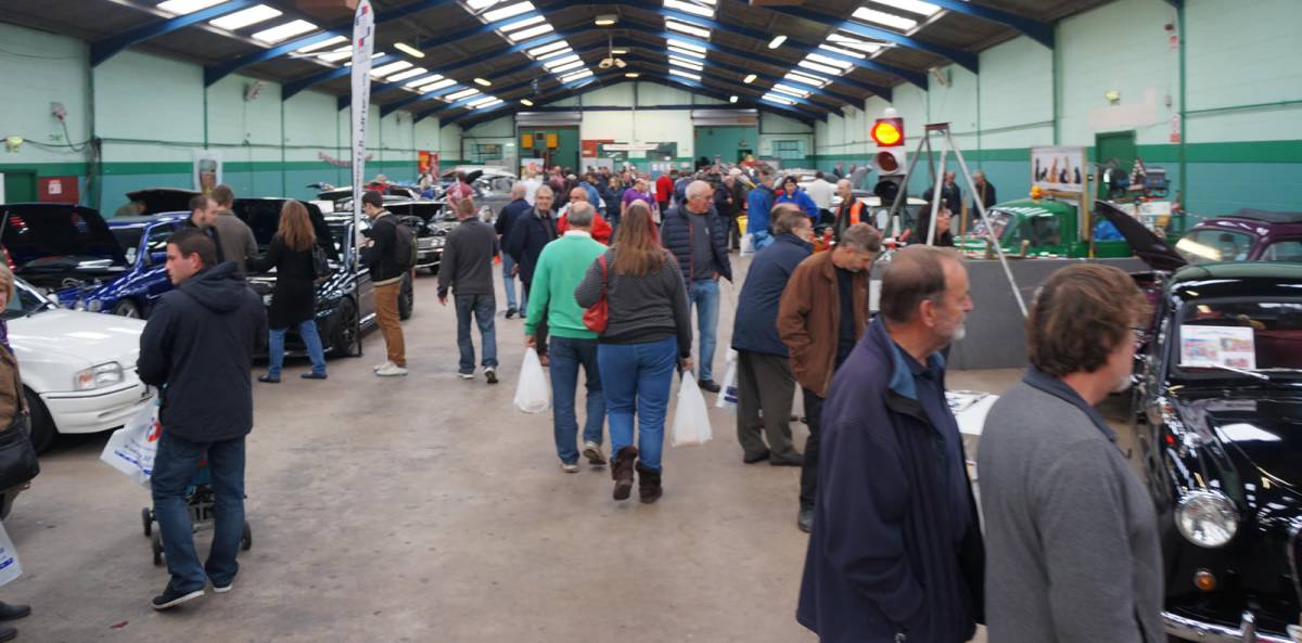 Classic car exhibition at Bath & West Showground, featuring diverse attendees and vibrant displays.