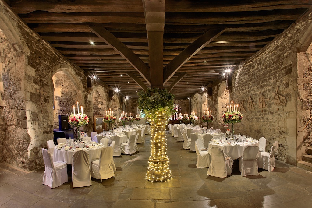 Elegant banquet hall in The Crypt, featuring rustic stone walls for weddings and events.