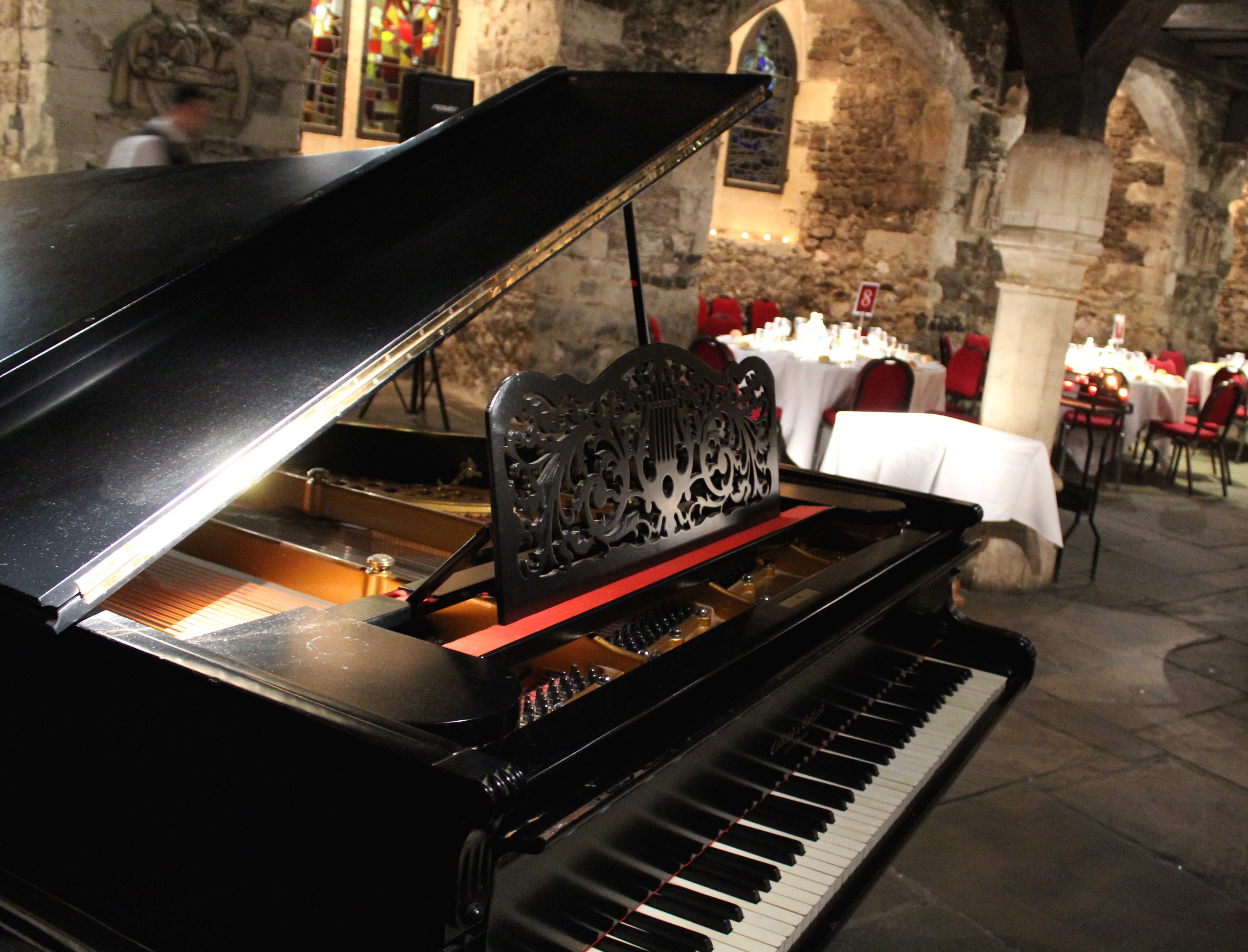 Elegant event space in The Crypt with grand piano, ideal for live music and gatherings.
