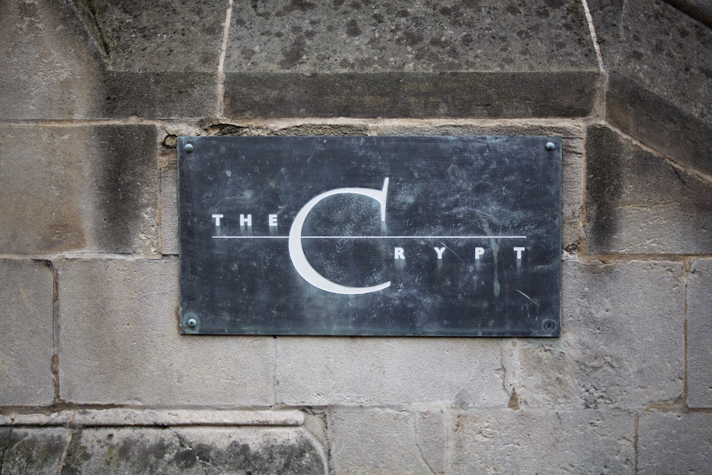 "The Crypt venue sign on stone backdrop, ideal for unique events and gatherings."