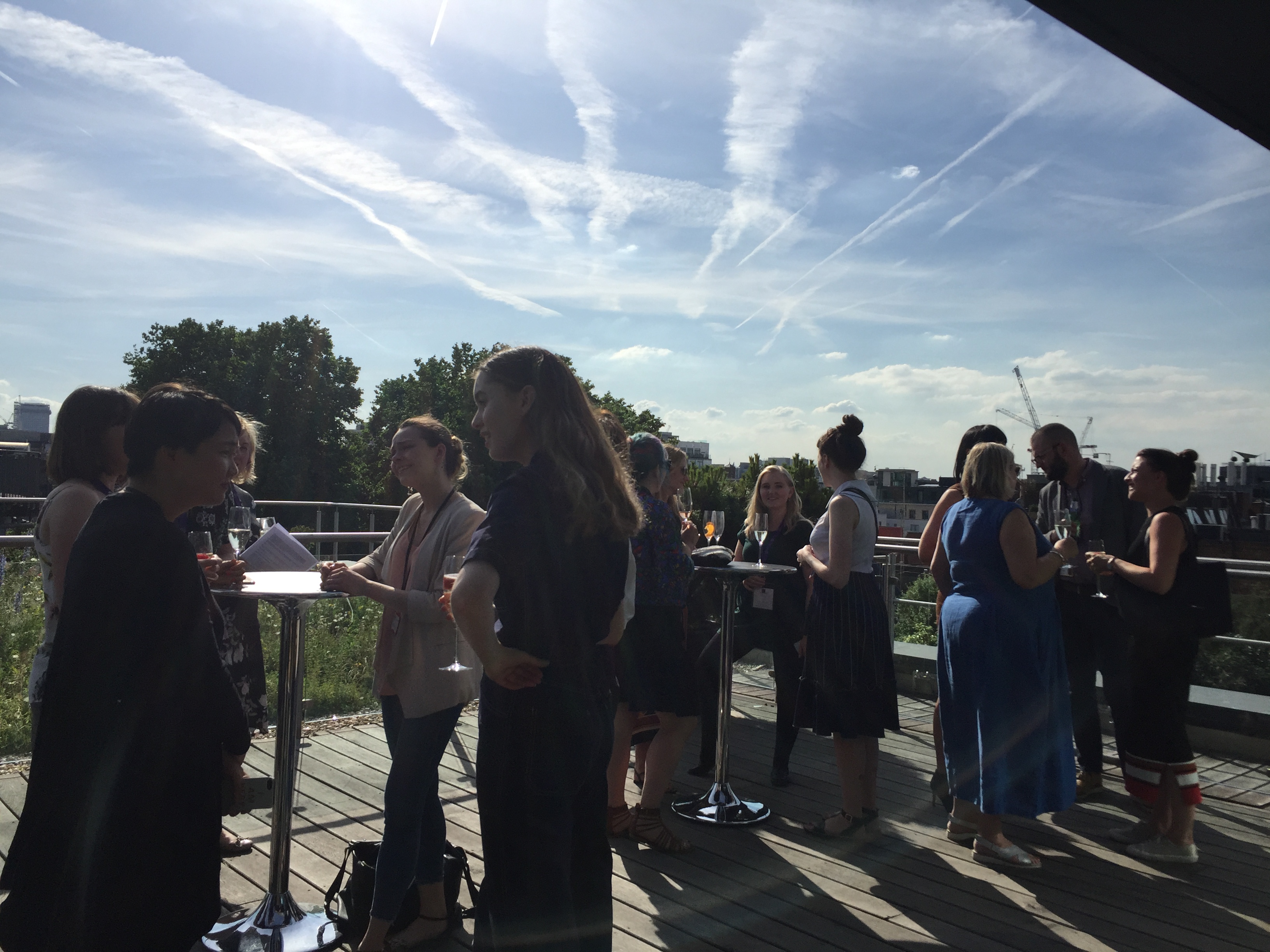 Outdoor networking event in Agas Harding Conference Room with city views and high-top tables.
