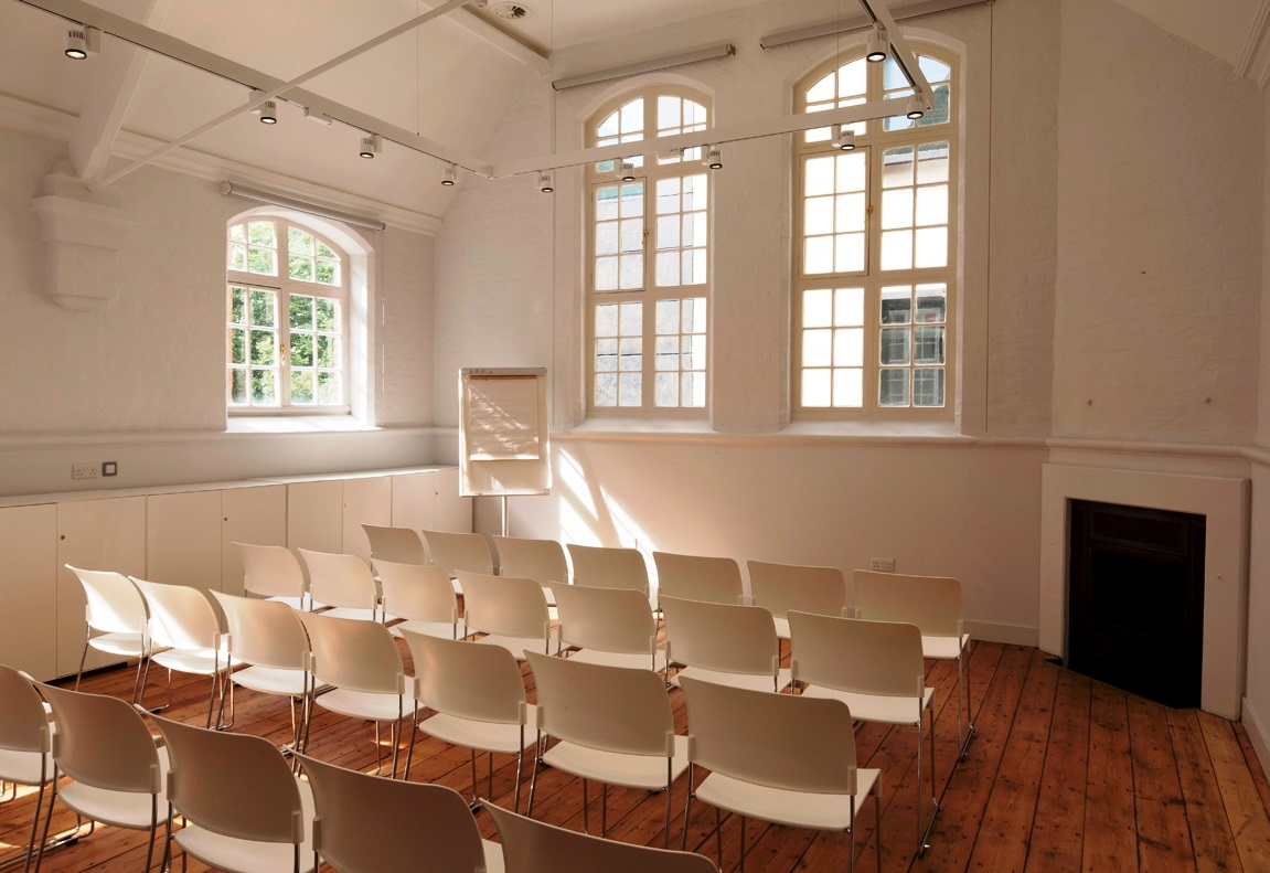 Minimalist meeting space with white chairs at The Goldsmiths' Centre for workshops and presentations.