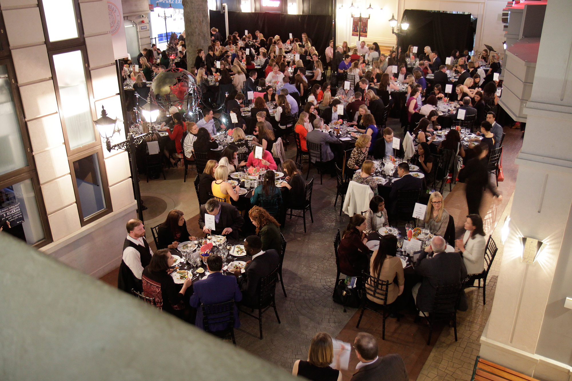 Main Square in KidZania London, elegant tables at a vibrant networking event.