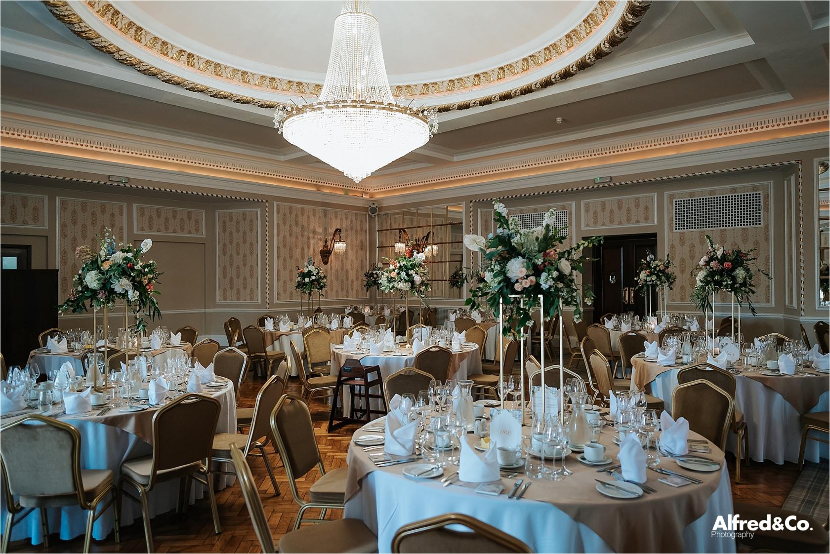 Elegant banquet hall with floral centerpieces, ideal for weddings and corporate events.