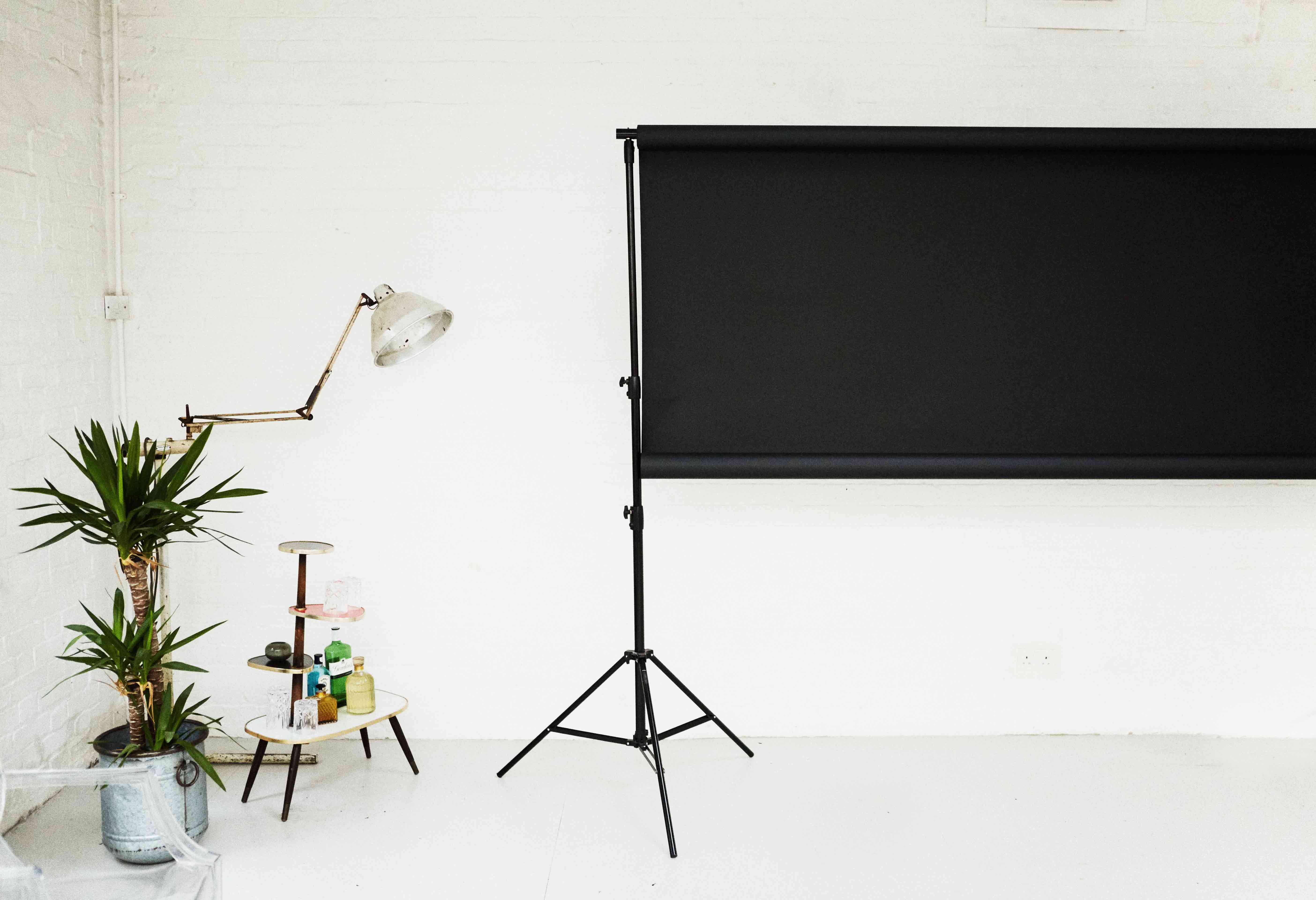 Minimalist event space with black screen for presentations and workshops.