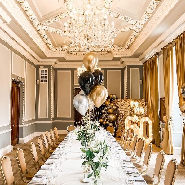 Elegant event space in Manchester Hall with gold and black decor for milestone celebrations.