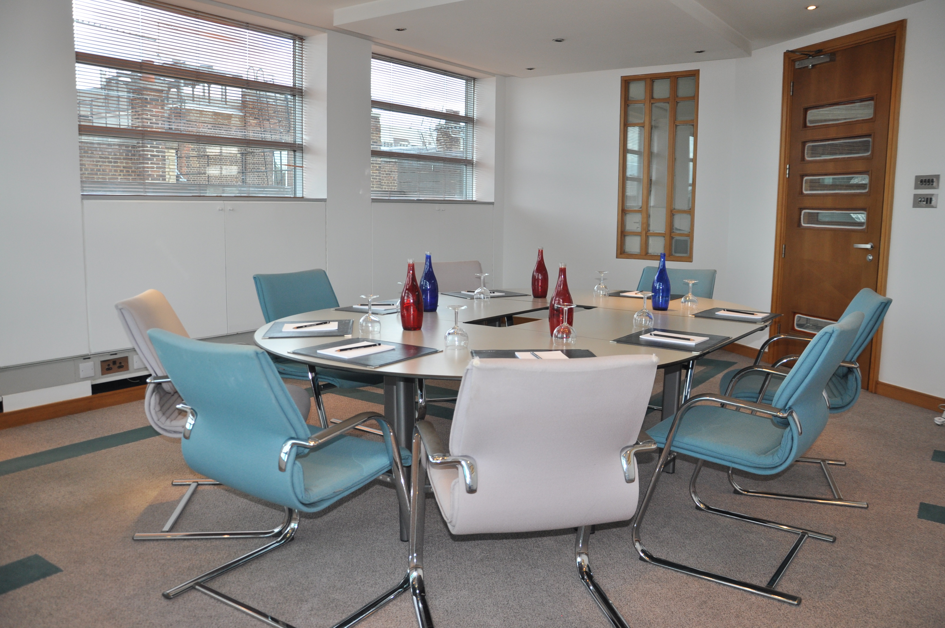 Modern boardroom with oval table, ideal for meetings and brainstorming sessions.