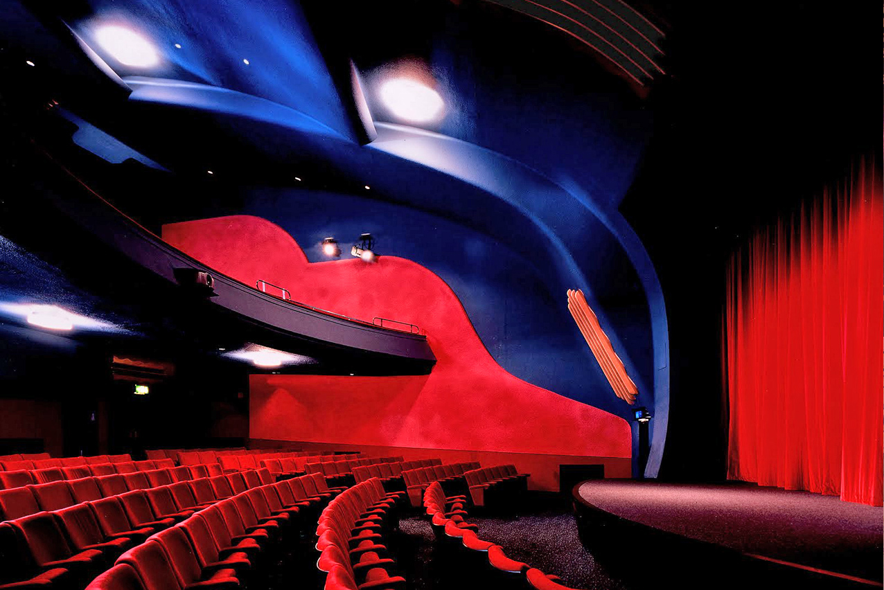 Auditorium at Rio Cinema with vibrant blue-red design, perfect for corporate events and shows.