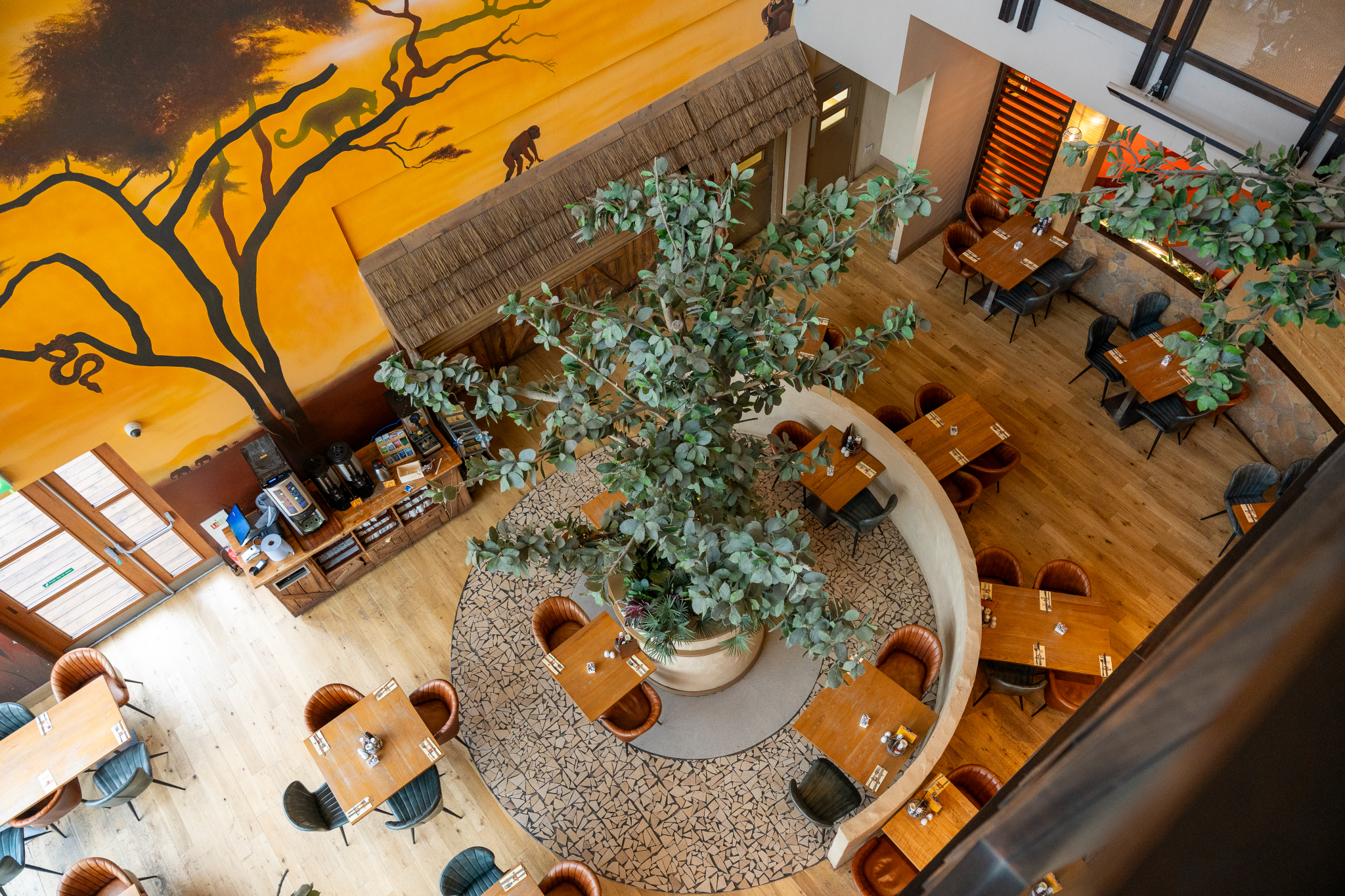 Serengeti Suite at Chessington: vibrant restaurant with central tree, ideal for events.
