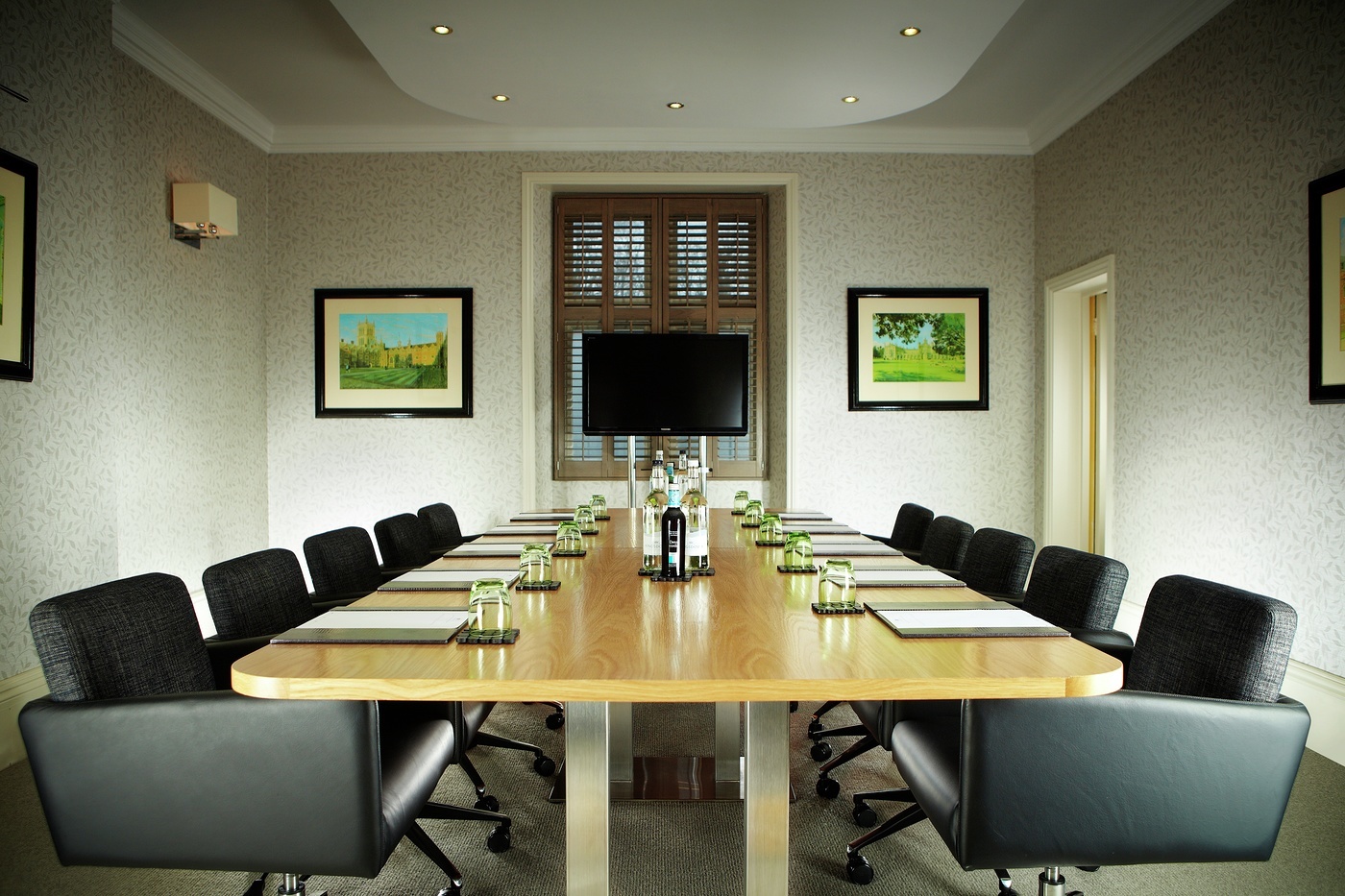 Boardroom at Alexander House Hotel with wooden table, ideal for professional meetings and presentations.