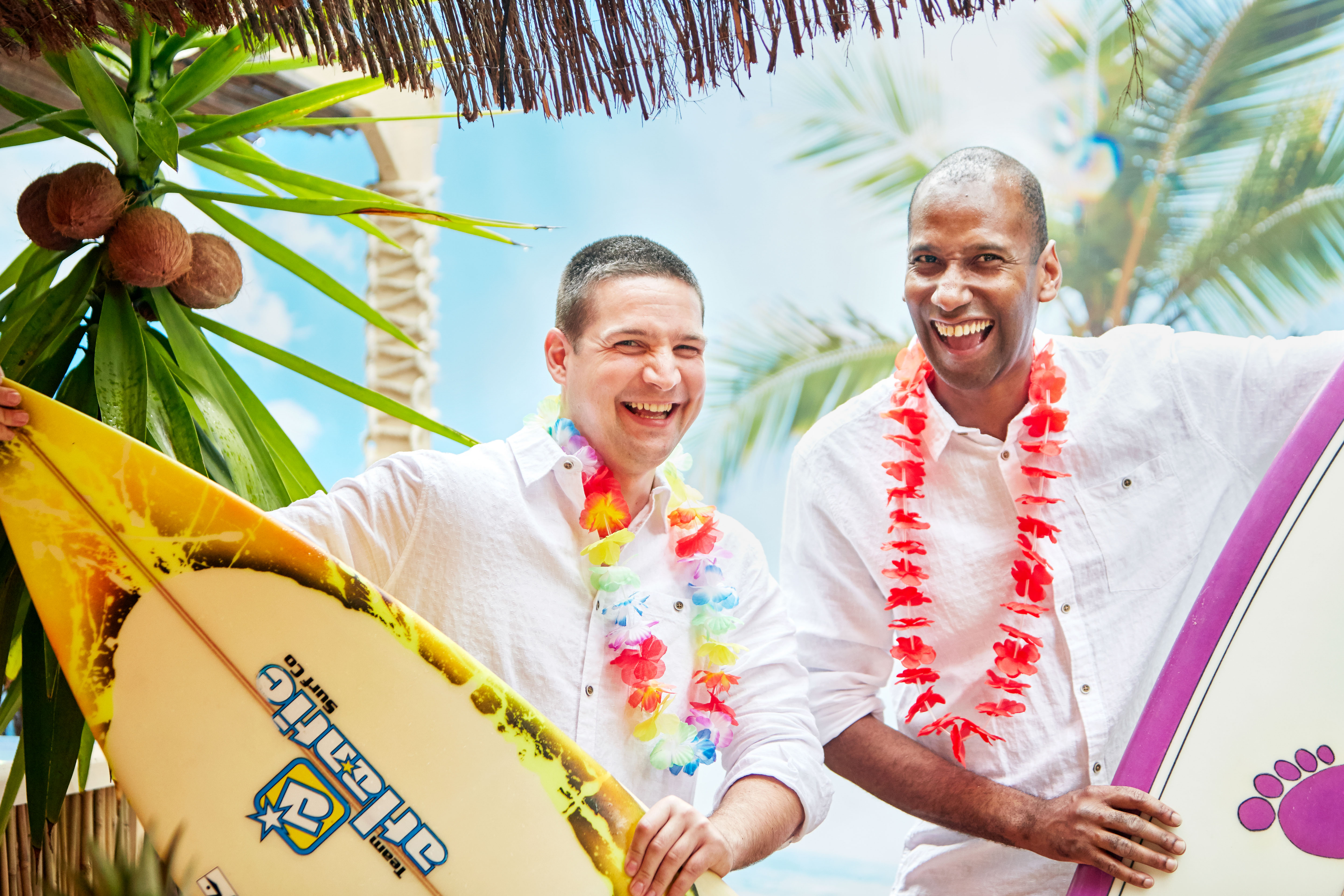 Tropical team-building event at The Beach Bar with surfboards and palm trees.