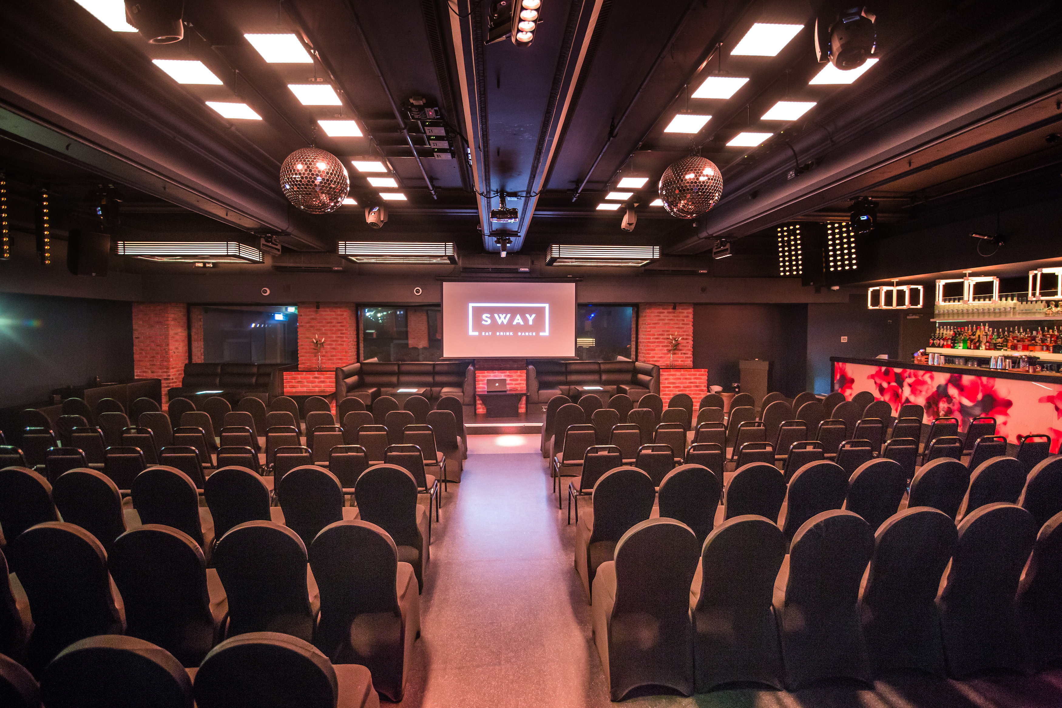 Modern event space in Sway with black chairs, ideal for corporate gatherings and presentations.