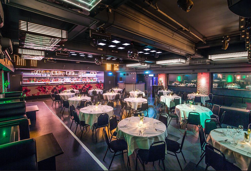 Stylish event space in Sway with round tables, ideal for corporate gatherings and celebrations.