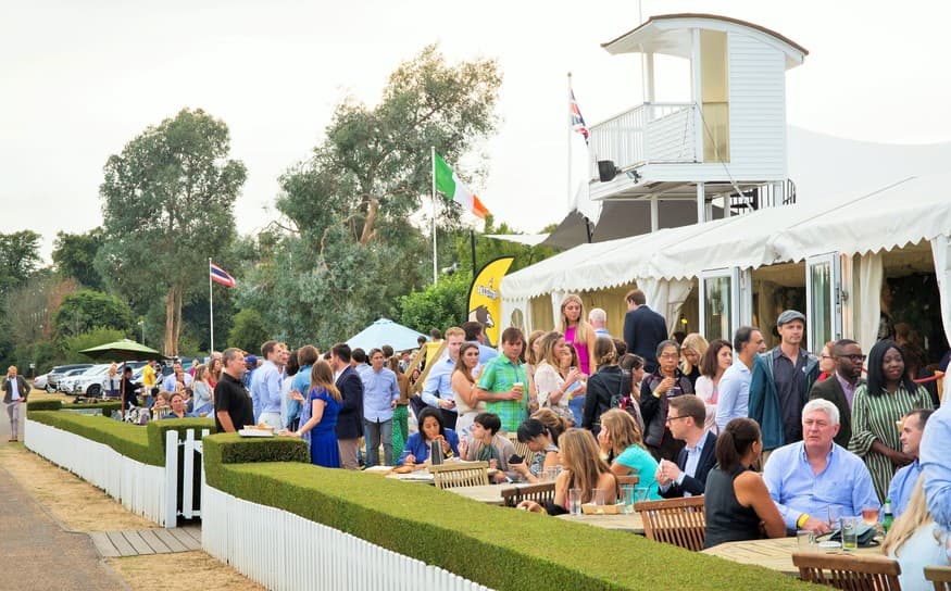 Outdoor event at Ham Polo Club with guests enjoying refreshments under a stylish marquee.