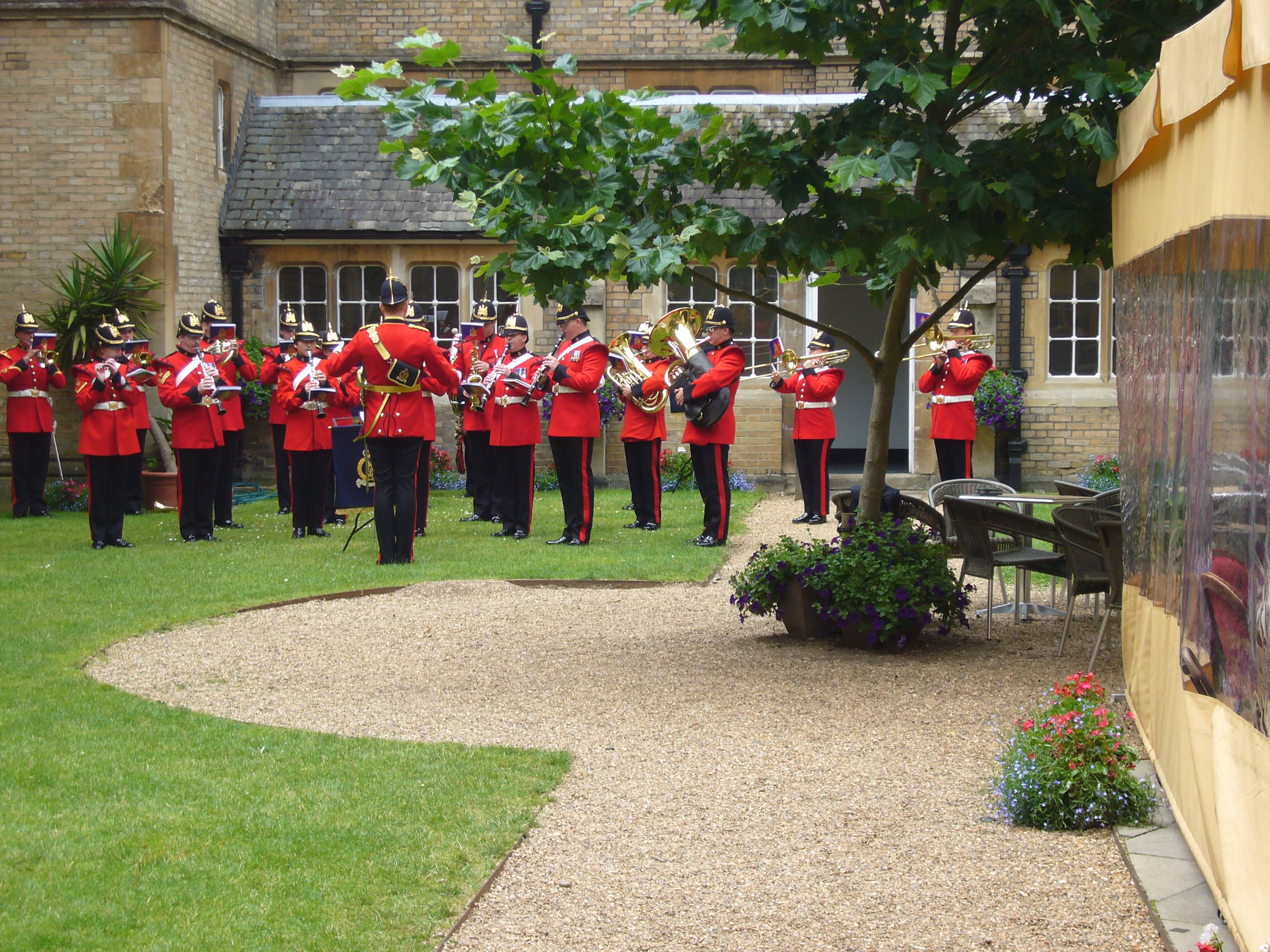 Brass band performing in a lush garden at a corporate event in Le Gothique.