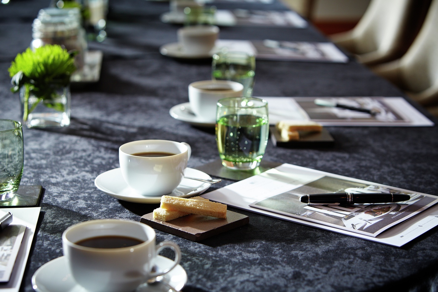 Elegant meeting setup at Mulberry, Langshott Manor Hotel with coffee cups and greenery.