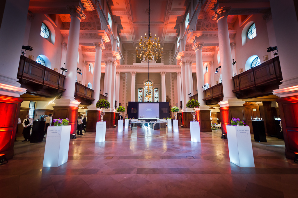Elegant event space in Christ Church Spitalfields with illuminated pedestals for gatherings.
