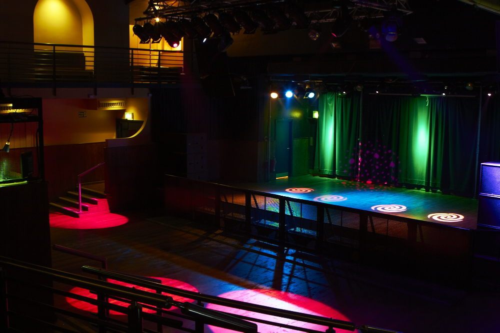 Versatile Scala venue with colorful stage lighting for corporate and social events.