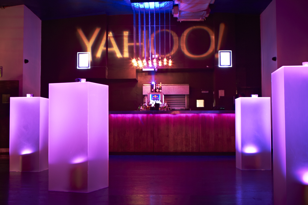 Vibrant Scala venue with sleek bar and "YAHOO!" projection for corporate events.