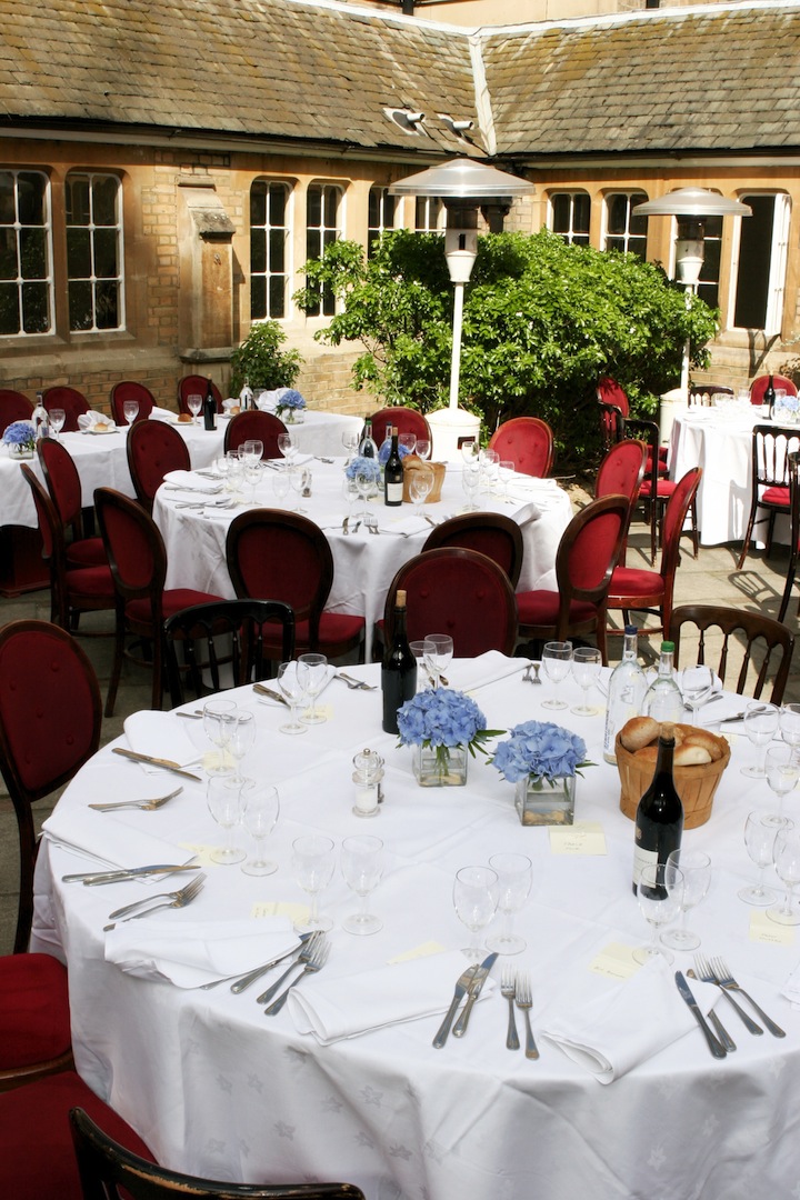 Elegant outdoor dining setup with floral centerpieces for a sophisticated event.