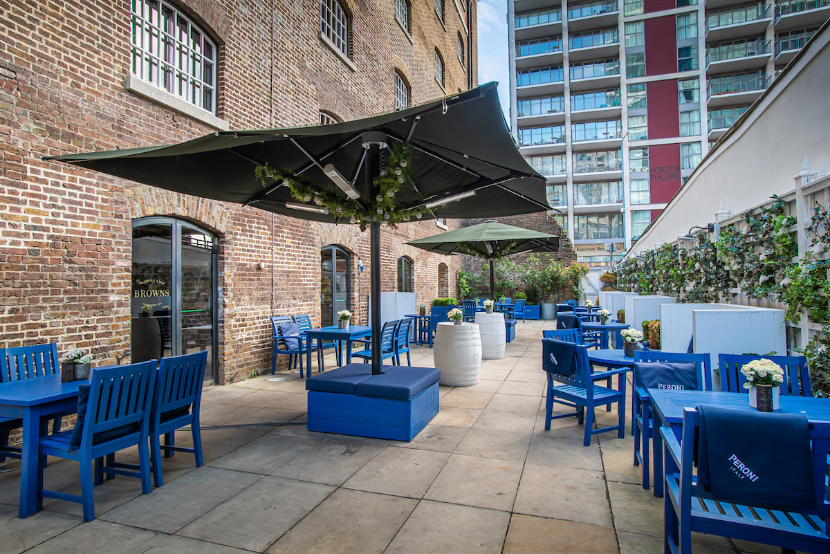 Stylish outdoor event space at Cellar Bar with blue furniture, ideal for gatherings.
