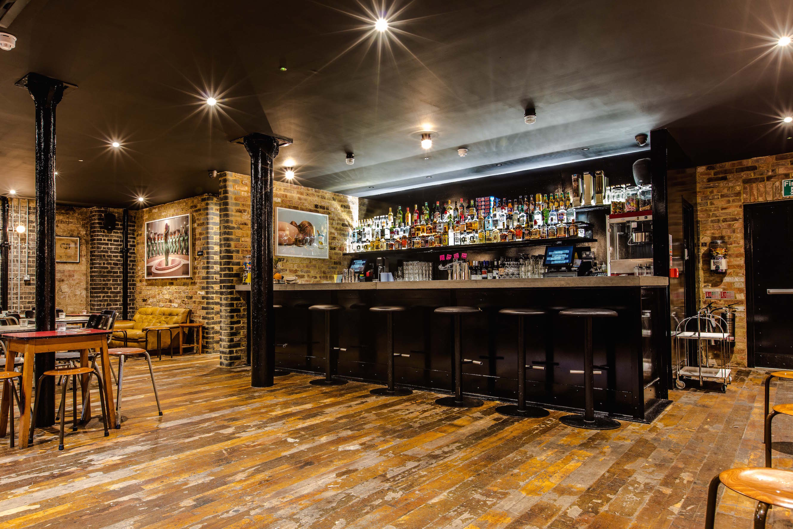Stylish Basement Bar with exposed brick, perfect for networking events and gatherings.