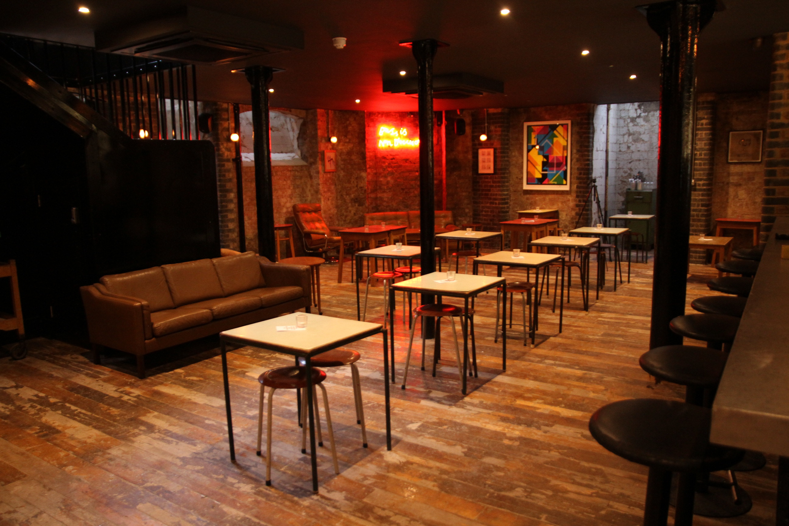 Basement Bar in Coin Laundry: cozy industrial event space with exposed brick, ideal for gatherings.