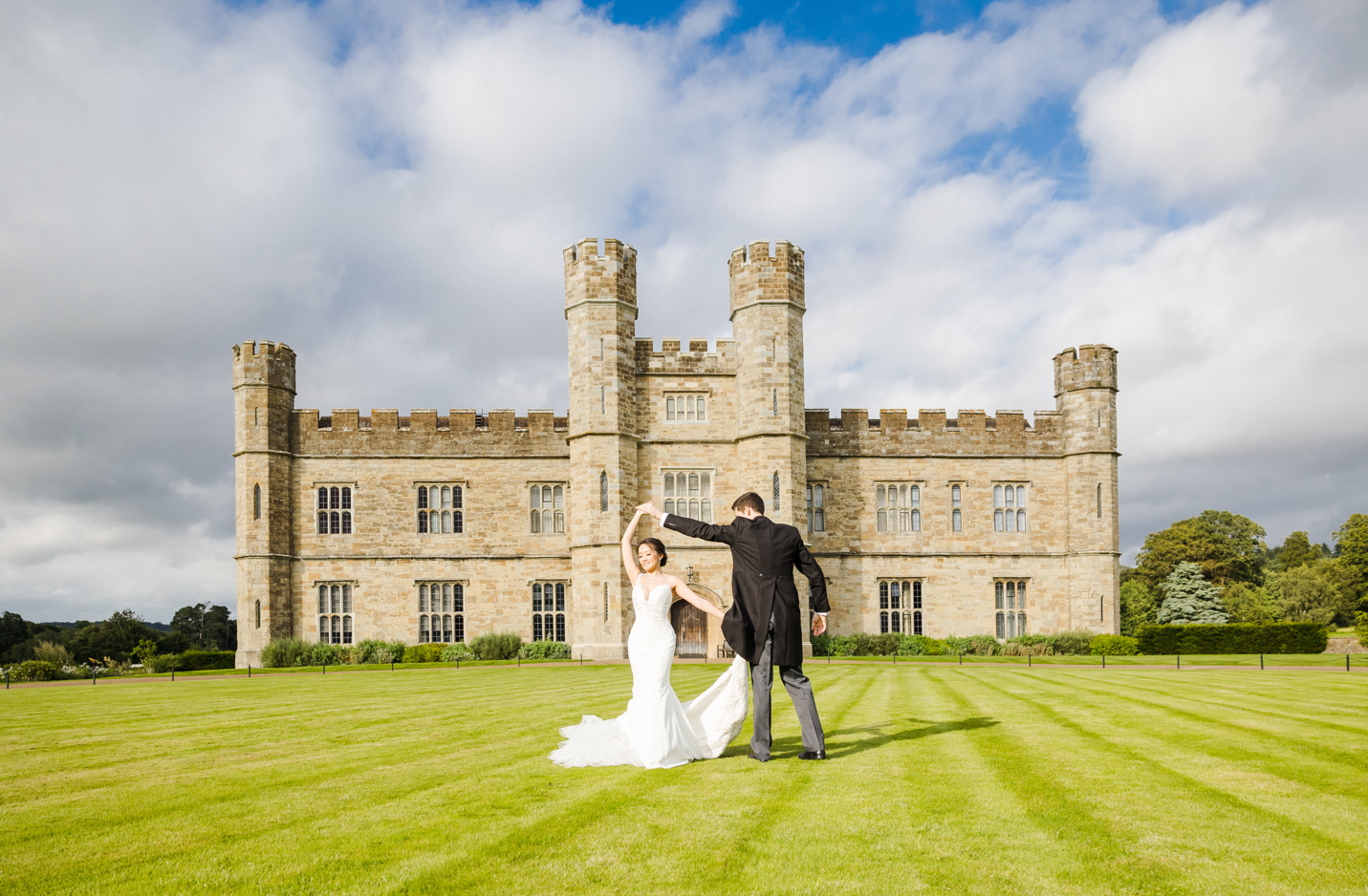 Outdoor wedding at Leeds Castle's Dining Room with lush lawn and majestic architecture.