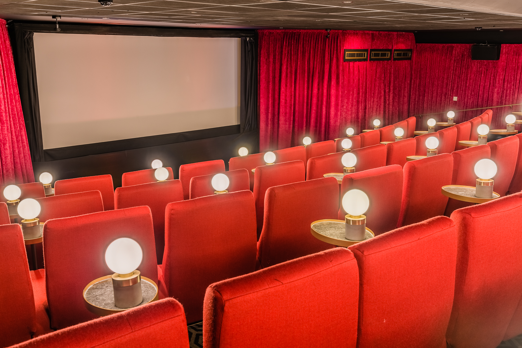 Cozy screening room with plush red seating for private film events at Curzon Mayfair.
