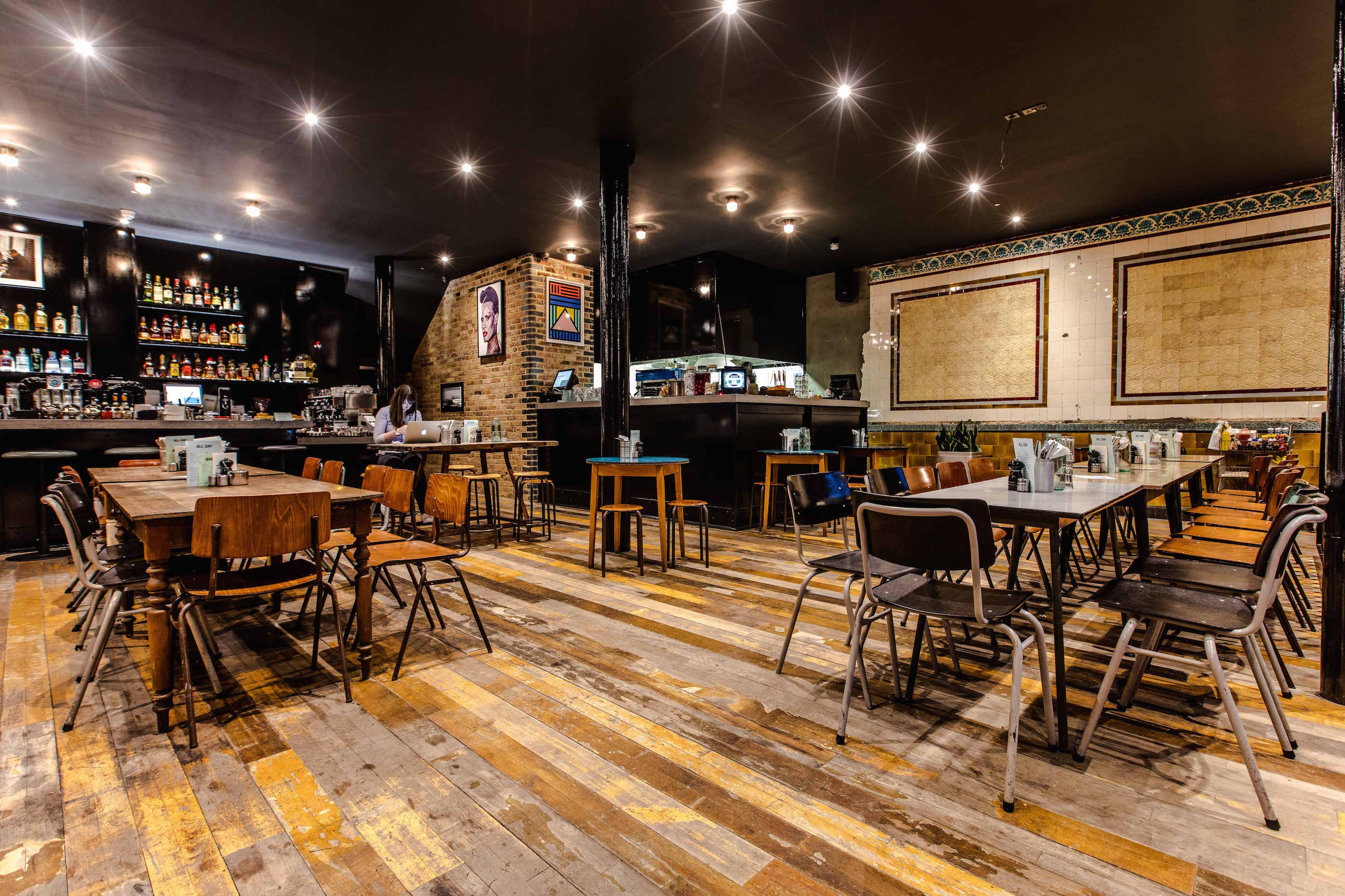 Versatile event space in Coin Laundry with rustic wooden flooring for gatherings.