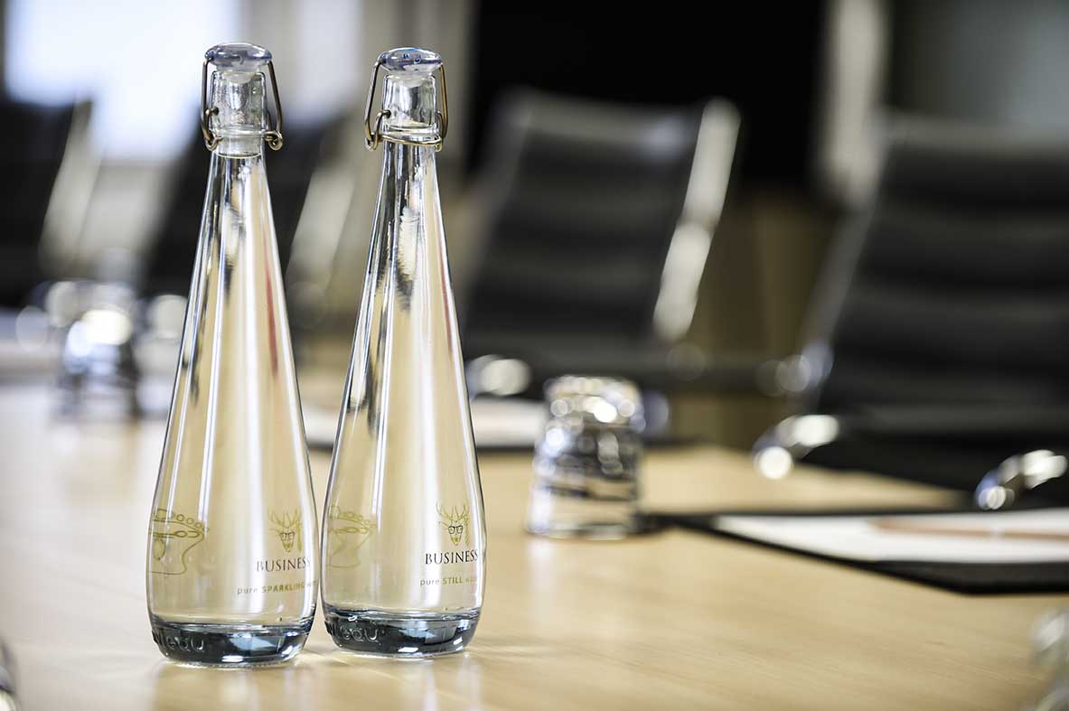 Marlow Suite conference table with elegant glass bottles for professional meetings.
