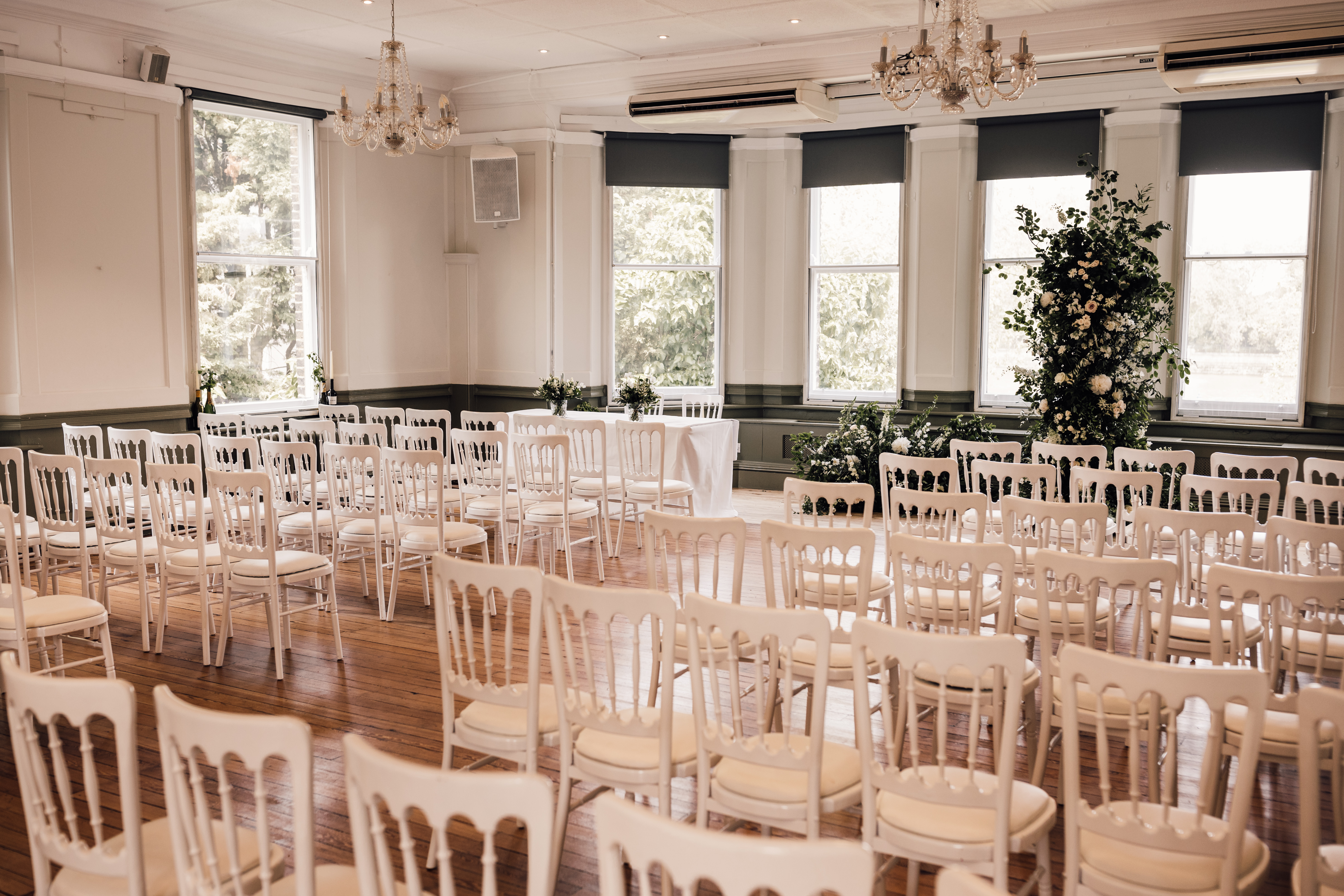 Elegant event space in Winchester House with white chairs, perfect for weddings or gatherings.