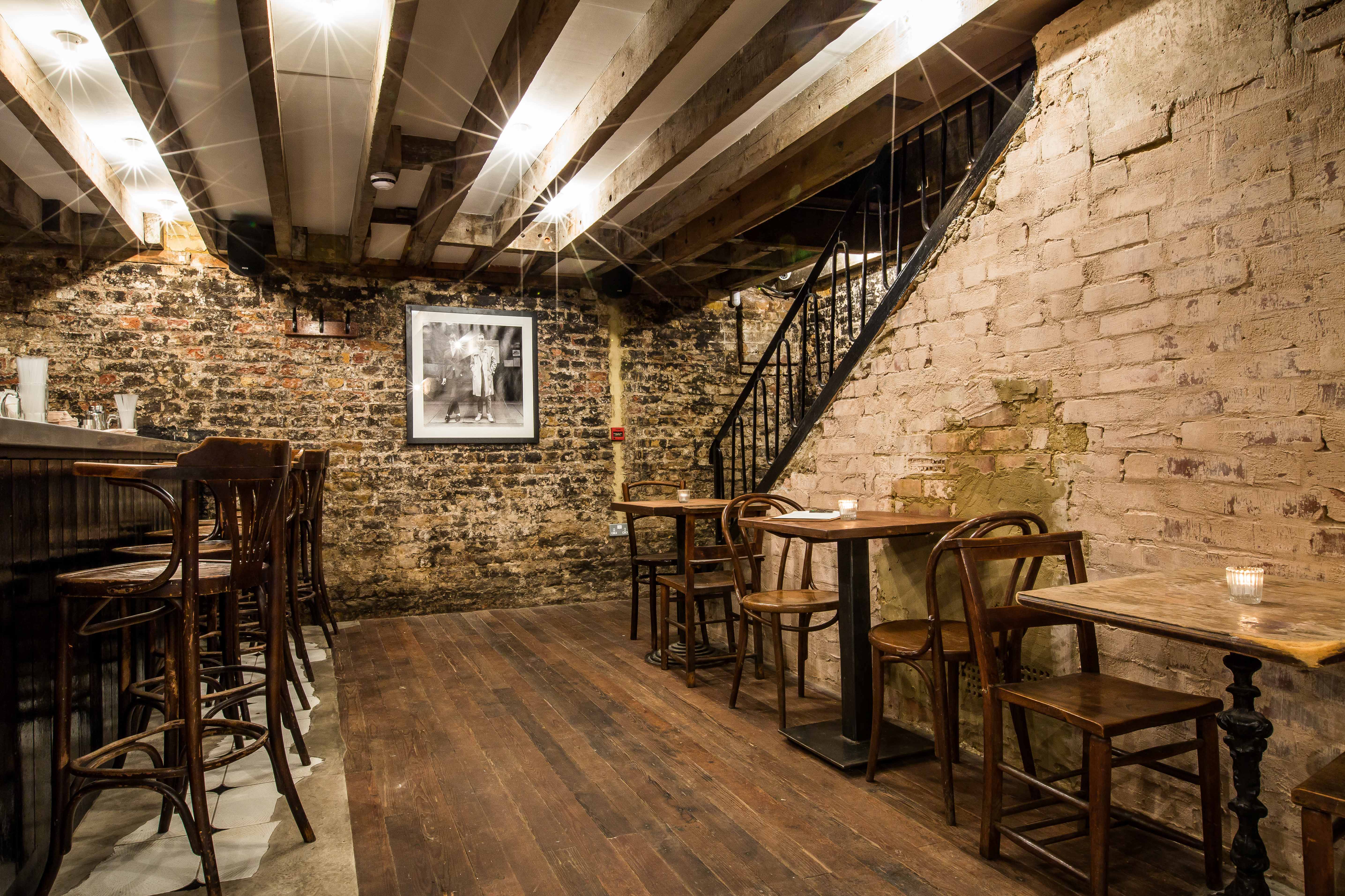 Cozy rustic basement venue with exposed brick for intimate gatherings and events.