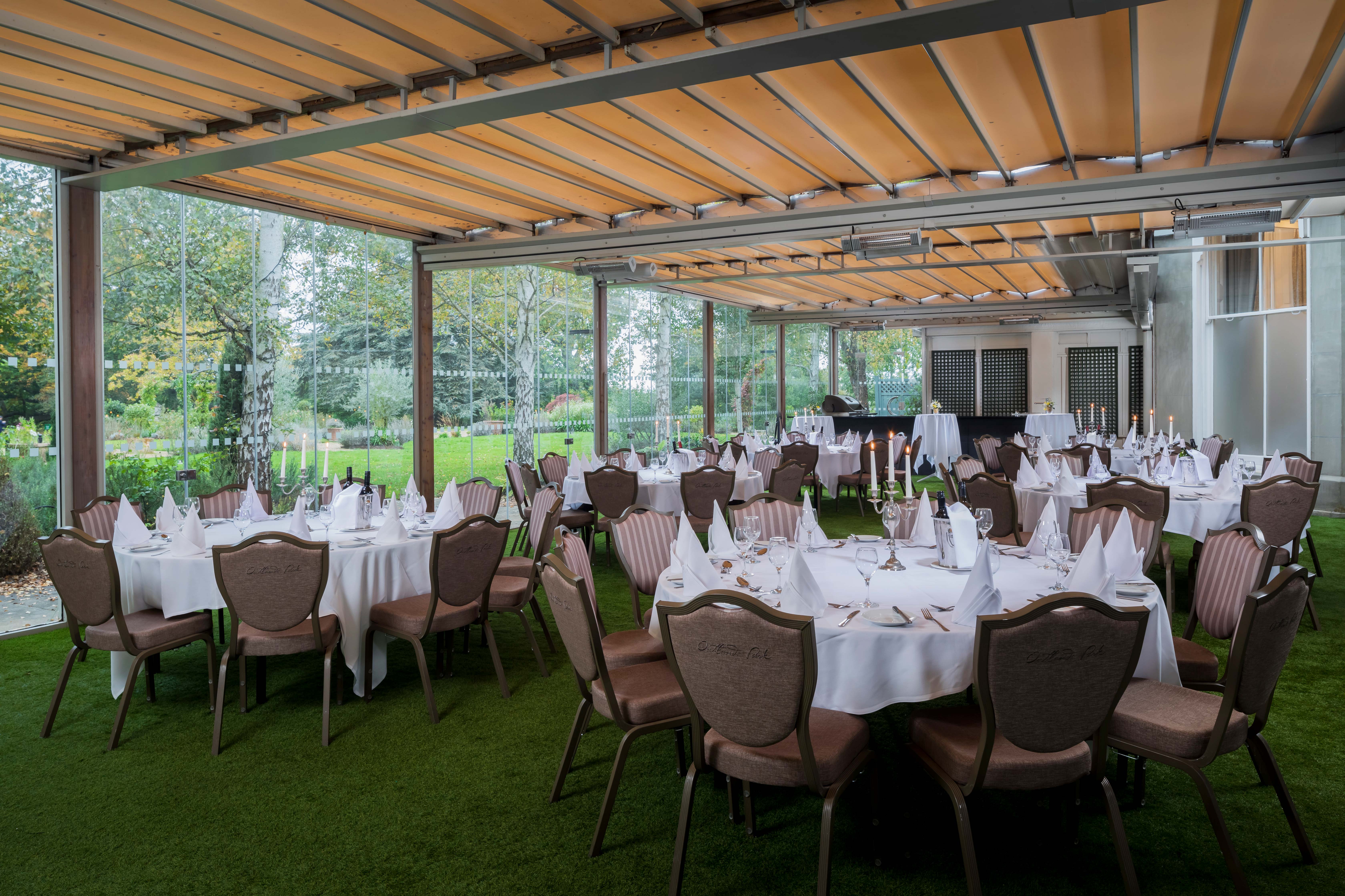 Elegant event space at Oatlands Park Hotel with round tables and natural light.