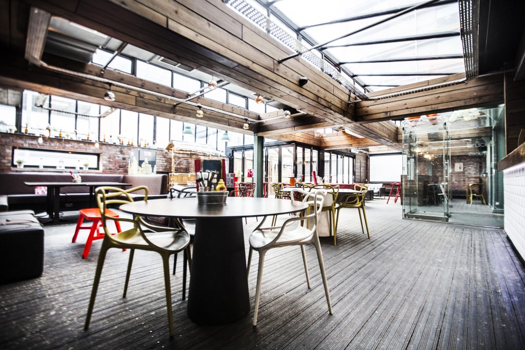 Modern event space with large windows, perfect for networking and casual meetings.