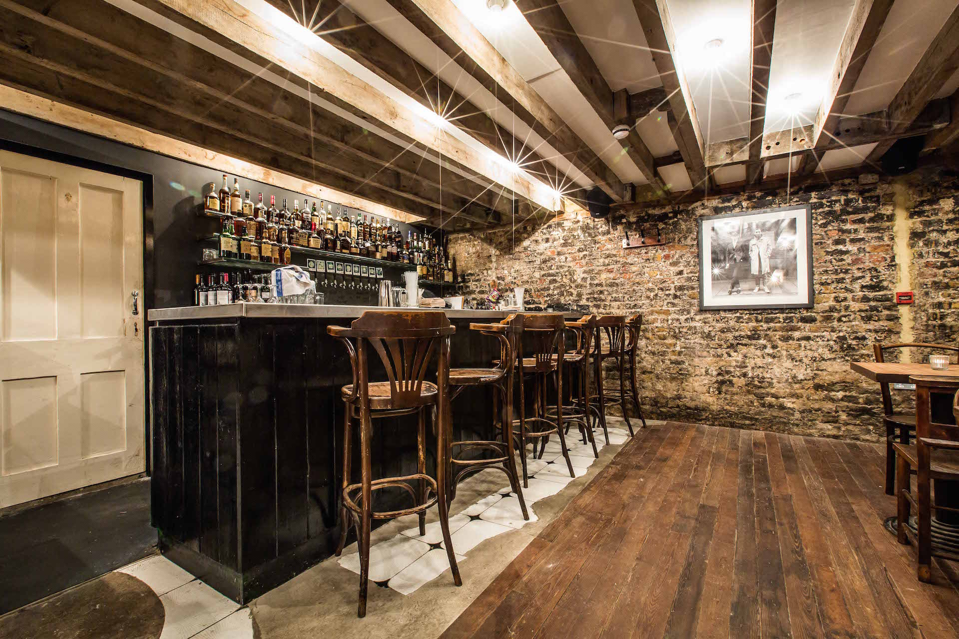 Cozy rustic bar venue with exposed brick, ideal for intimate gatherings and networking events.