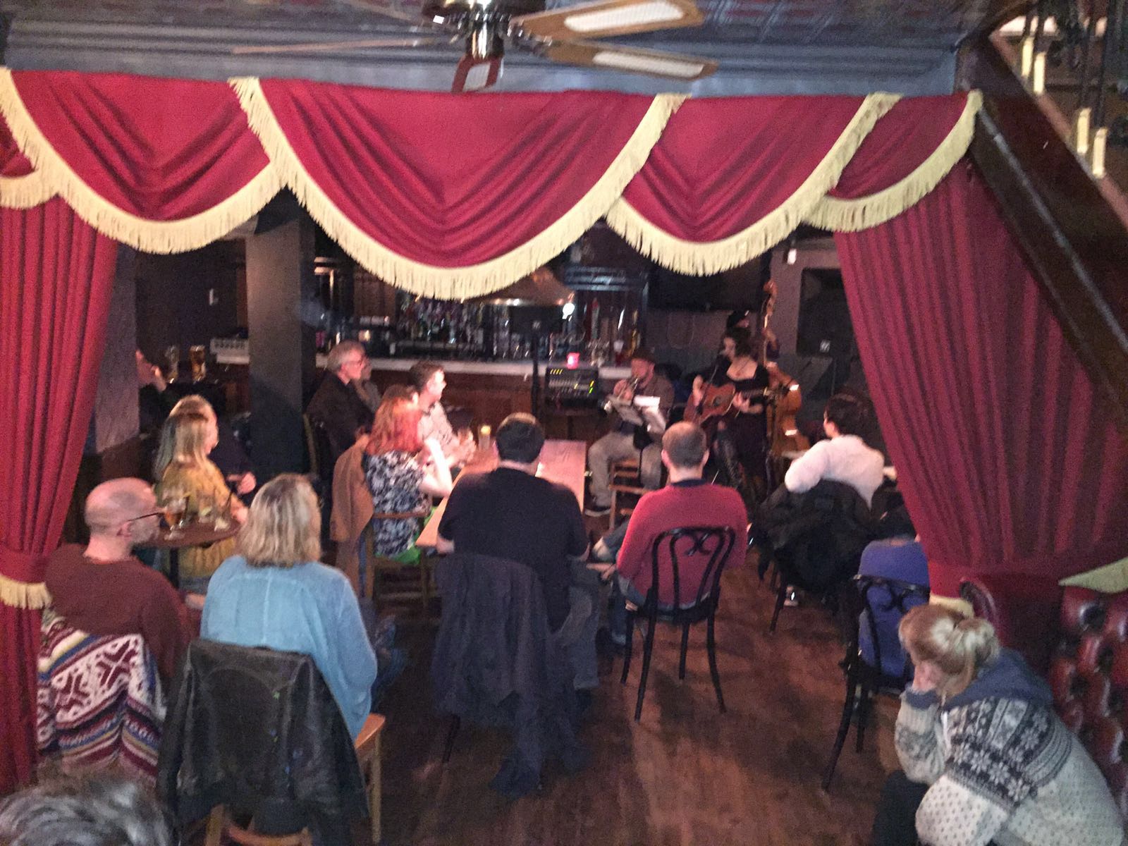 Intimate Rum and Rumour Kabaret Bar with red curtains for live performances and events.