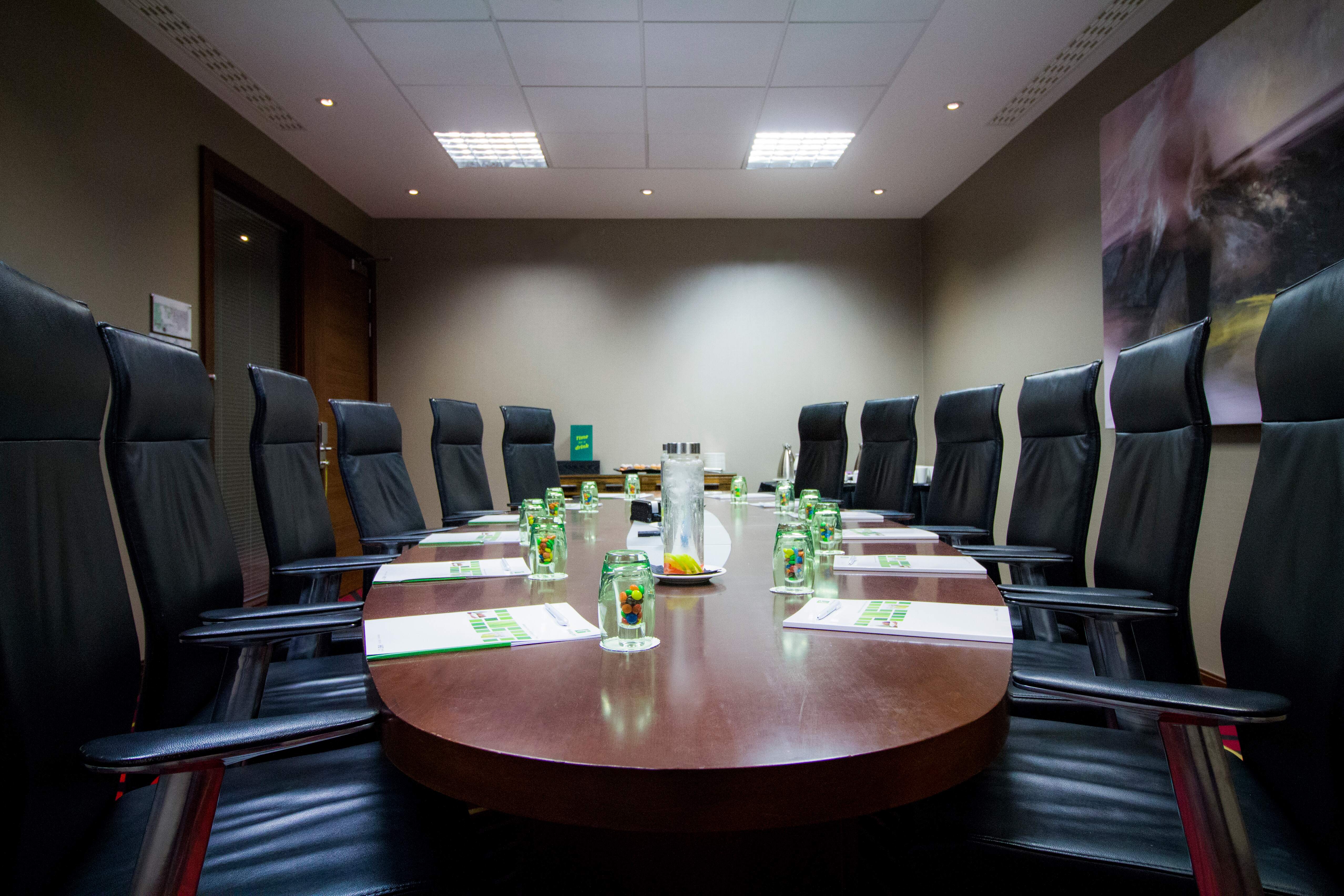 Executive Boardroom at Holiday Inn Kensington with sleek leather chairs for corporate meetings.